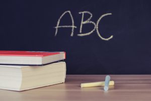 FCPS: chalkboard that says ABC and chalk and books on a table
