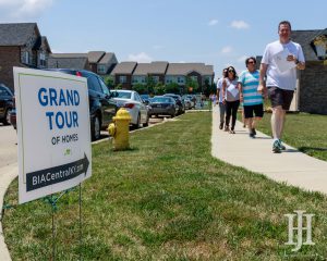Home and Garden: a sign that says gran tour of homes and people walking by
