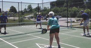Senior adults outside playing pickle ball