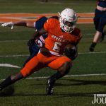 Lexington: high school student playing football in a orange uniform