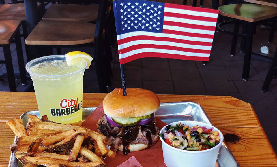 tray of fries, burger, southern mix, lemonade, and an american flag in the burger