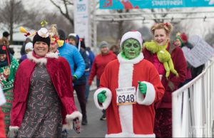 Holiday Guide: group of people dressed in christmas outfits running a race