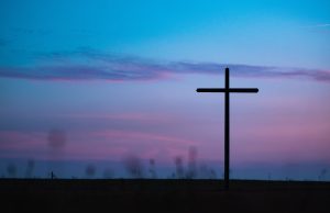ash wednesday: blue and purple sky with a cross silhouette
