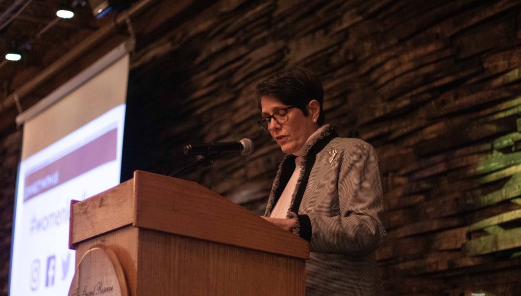 Women Leading Kentucky: woman in a blazer at a podium giving a speech