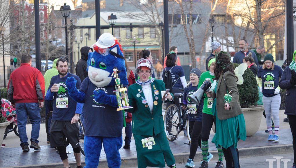 Shamrock Shuffle: a blue mascot and a woman dressed like an old woman smiling at the camera
