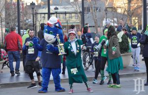 Shamrock Shuffle: a blue mascot and a woman dressed like an old woman smiling at the camera