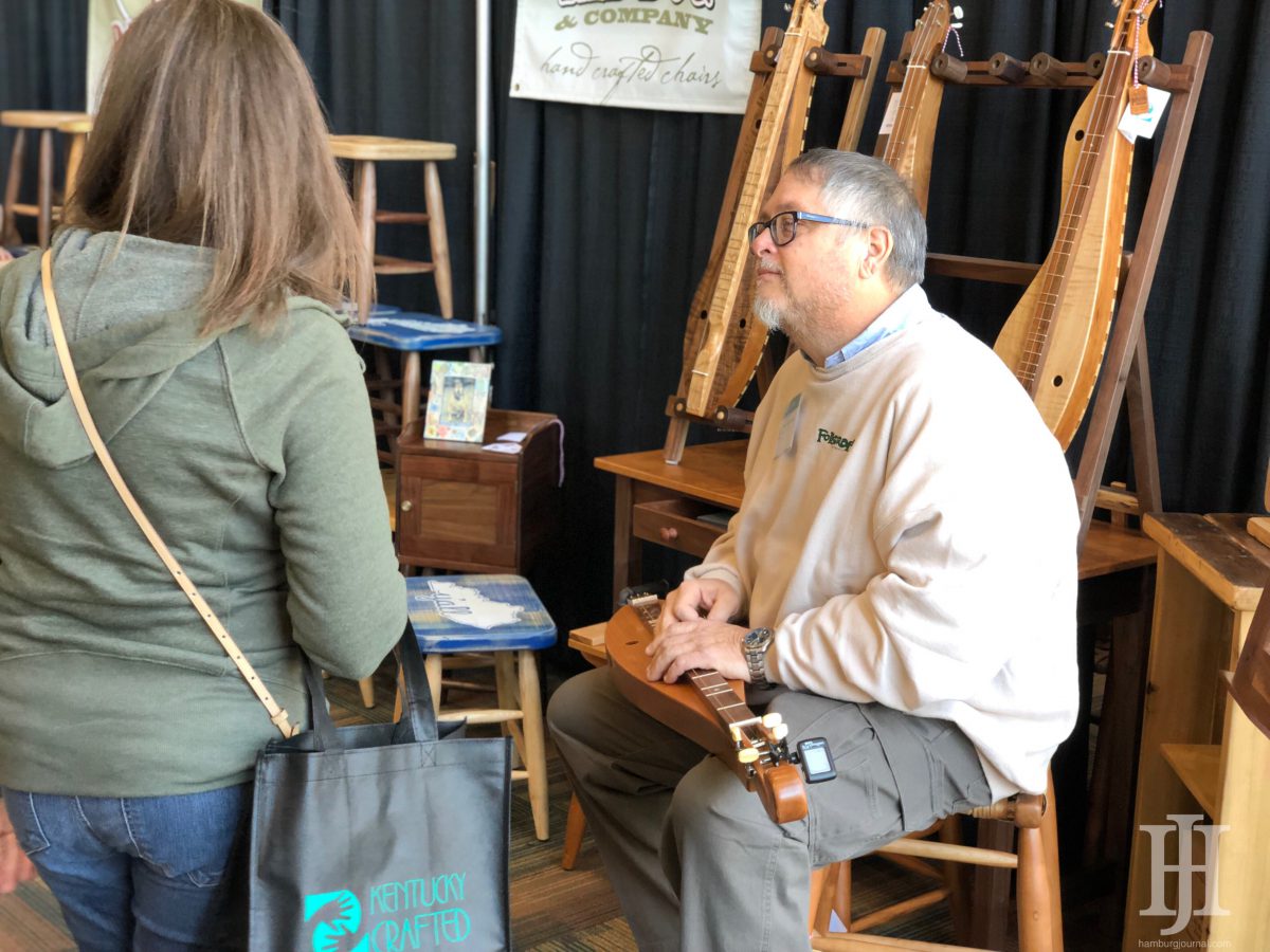 Kentucky Crafted Market: man with a wooden instrument talking to a woman