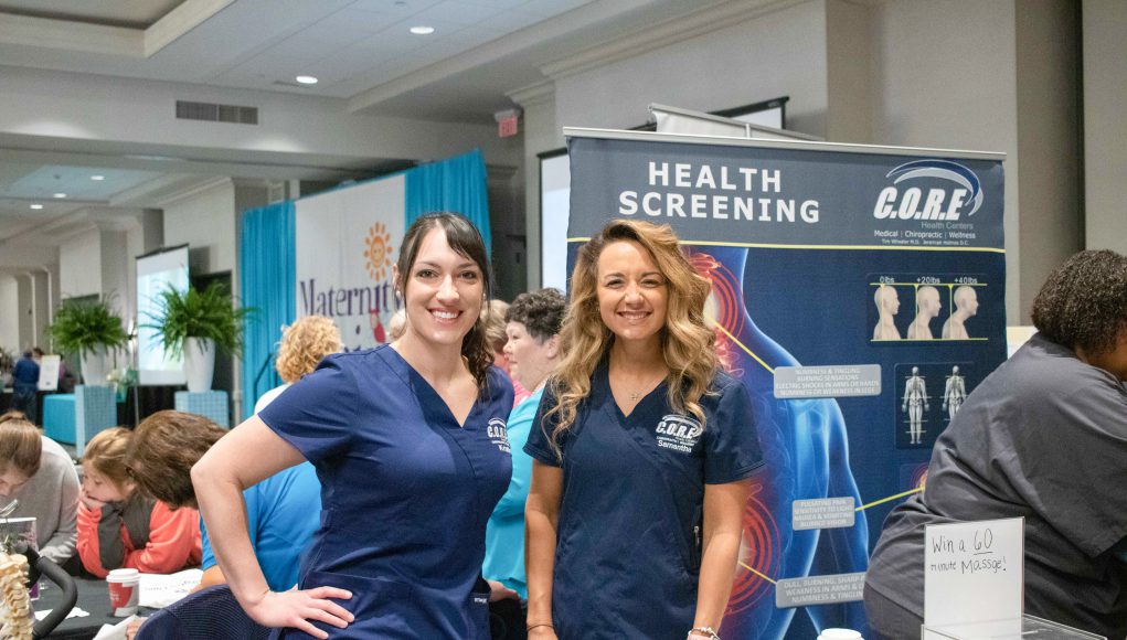 Health: two women dressed in scrubs smiling at the camera