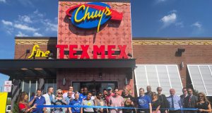Business: a building that says Chuy's Tex-Mex with a group of people standing in front of it