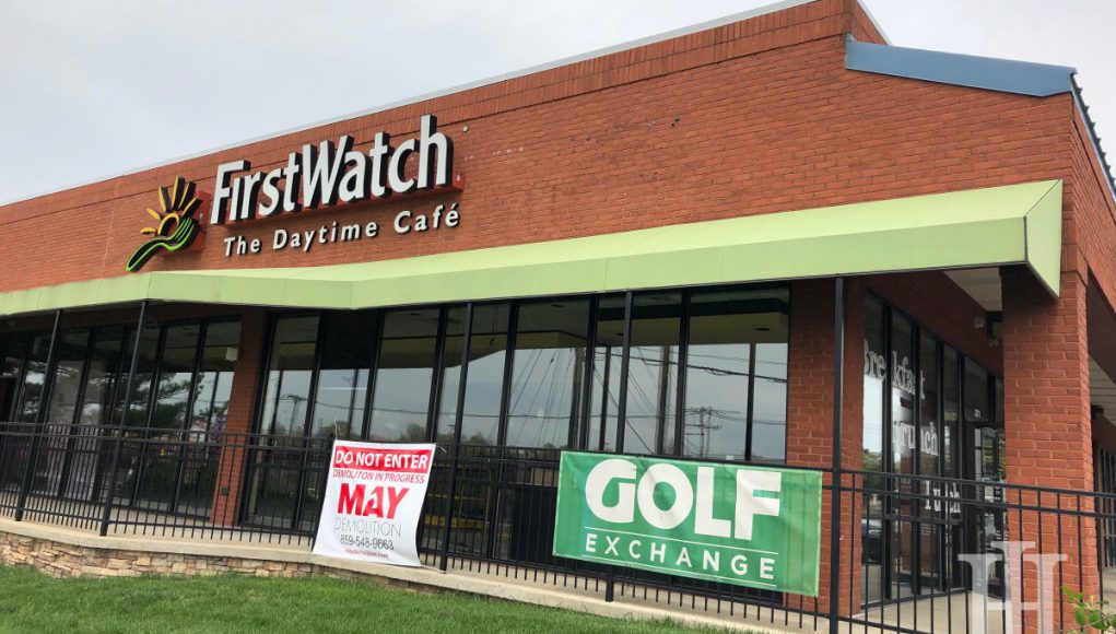 A building with a small black gate in front that says First Watch and a green sign that says Golf exchange