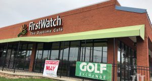 A building with a small black gate in front that says First Watch and a green sign that says Golf exchange
