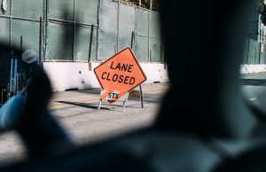 Work Zone: sign of an orange lane closed sign