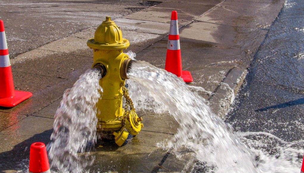 Flushing Program: a yellow hydrant with water coming out