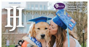 Hamburg Journal June 2019 Cover featuring a service dog and its trainer in graduation caps. gril is kissing dog. Dog is a golden retriver.