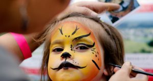 Festival: a girl getting her face painted like a tiger