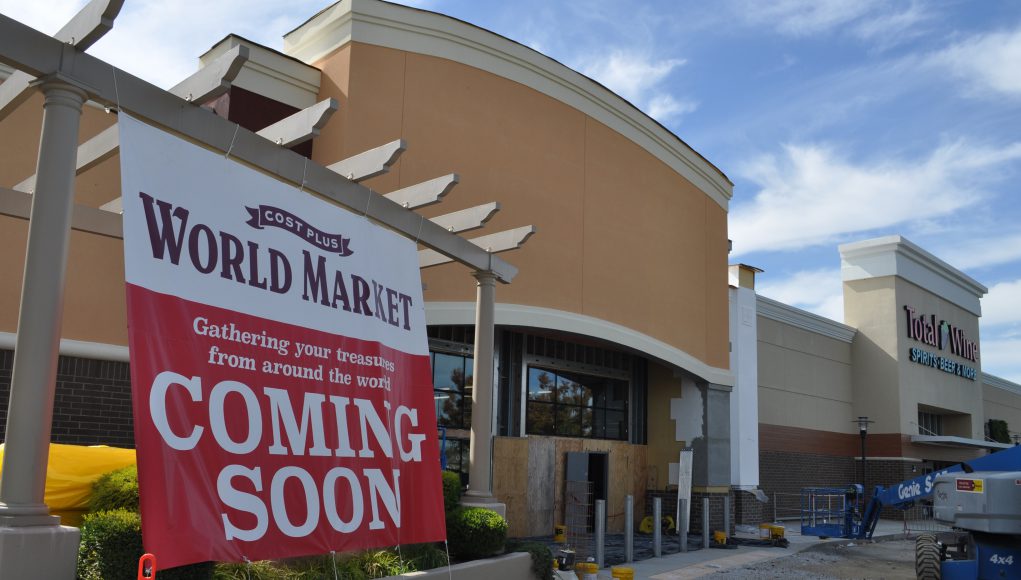 Cost Plus World Market Business: a coming soon sign with a building behind