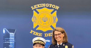 Family: a young boy and older woman dressed in fire chief uniforms